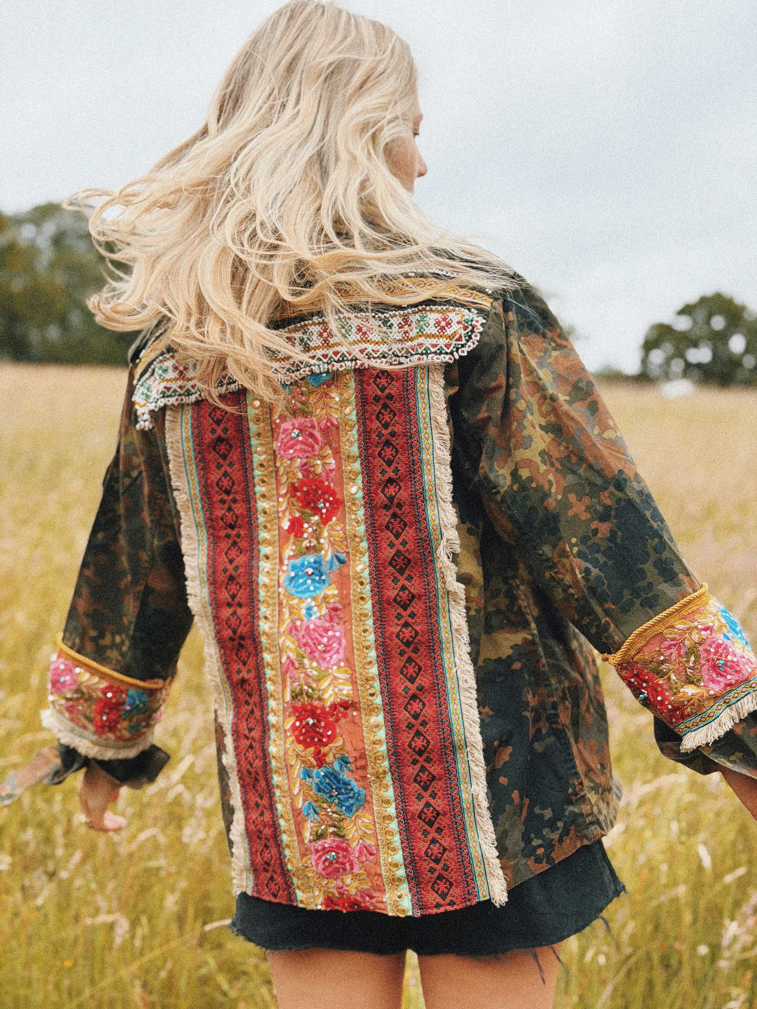Embellished camouflage jacket with colourful embroidered back panel and embroidered sleeve cuffs, shown from the back.