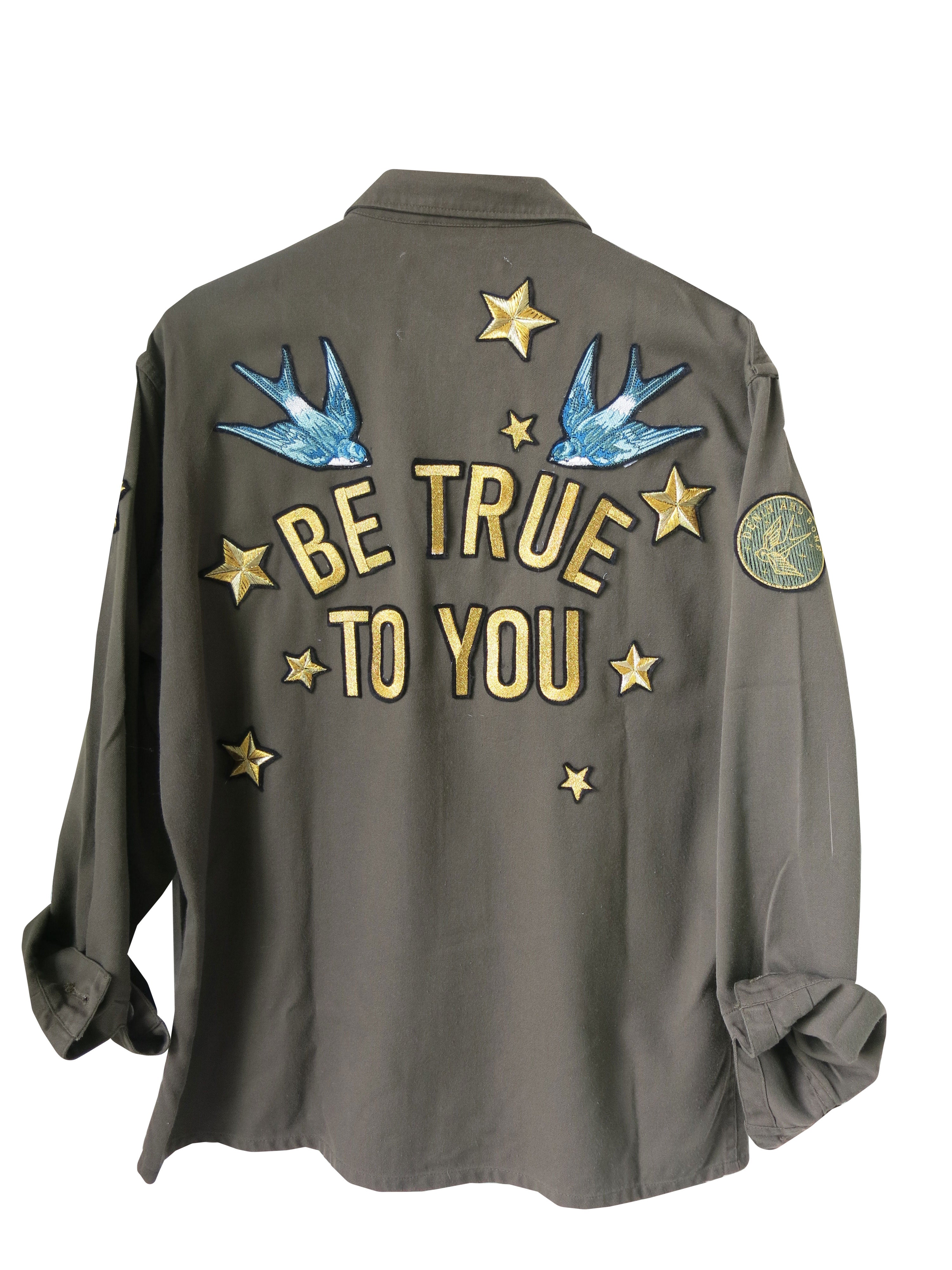 Khaki jacket with bohemian embroidery including the text 'BE TRUE TO YOU' and bird motifs, along with Denim and Bone army badges.