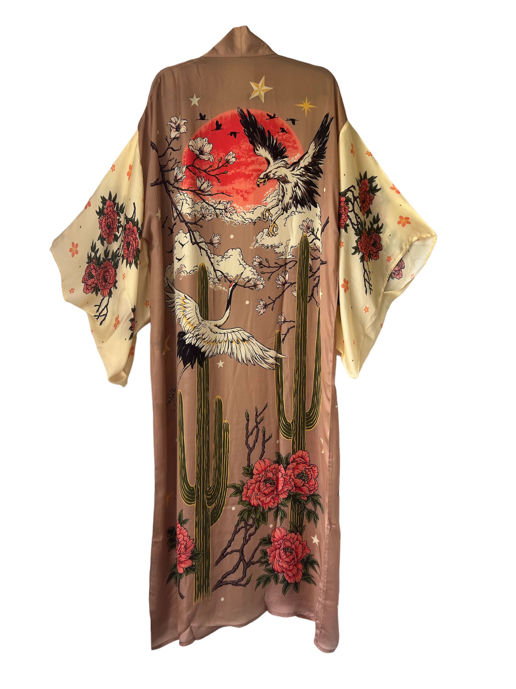 Back view of a blush pink kimono-style robe featuring soaring cranes, towering cacti, blooming flowers, an eagle, and a red sun graphic.