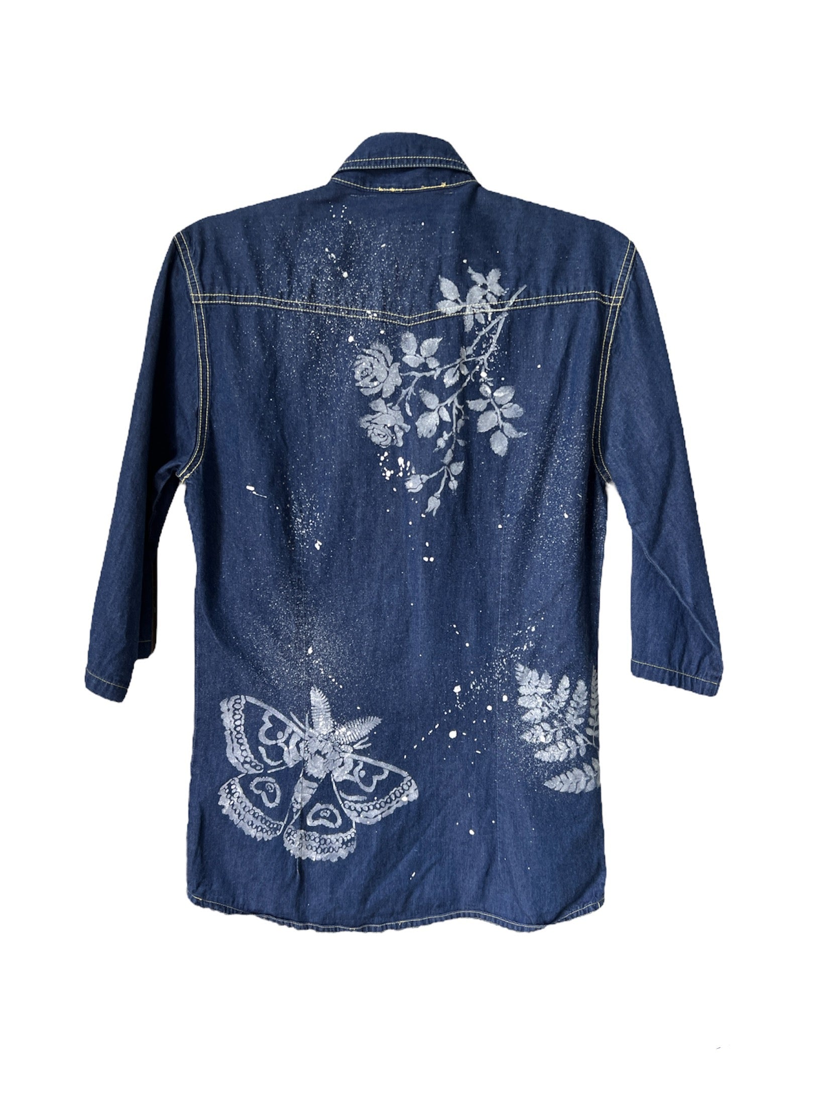 blue denim shirt with hand-painted white floral and butterfly artwork.