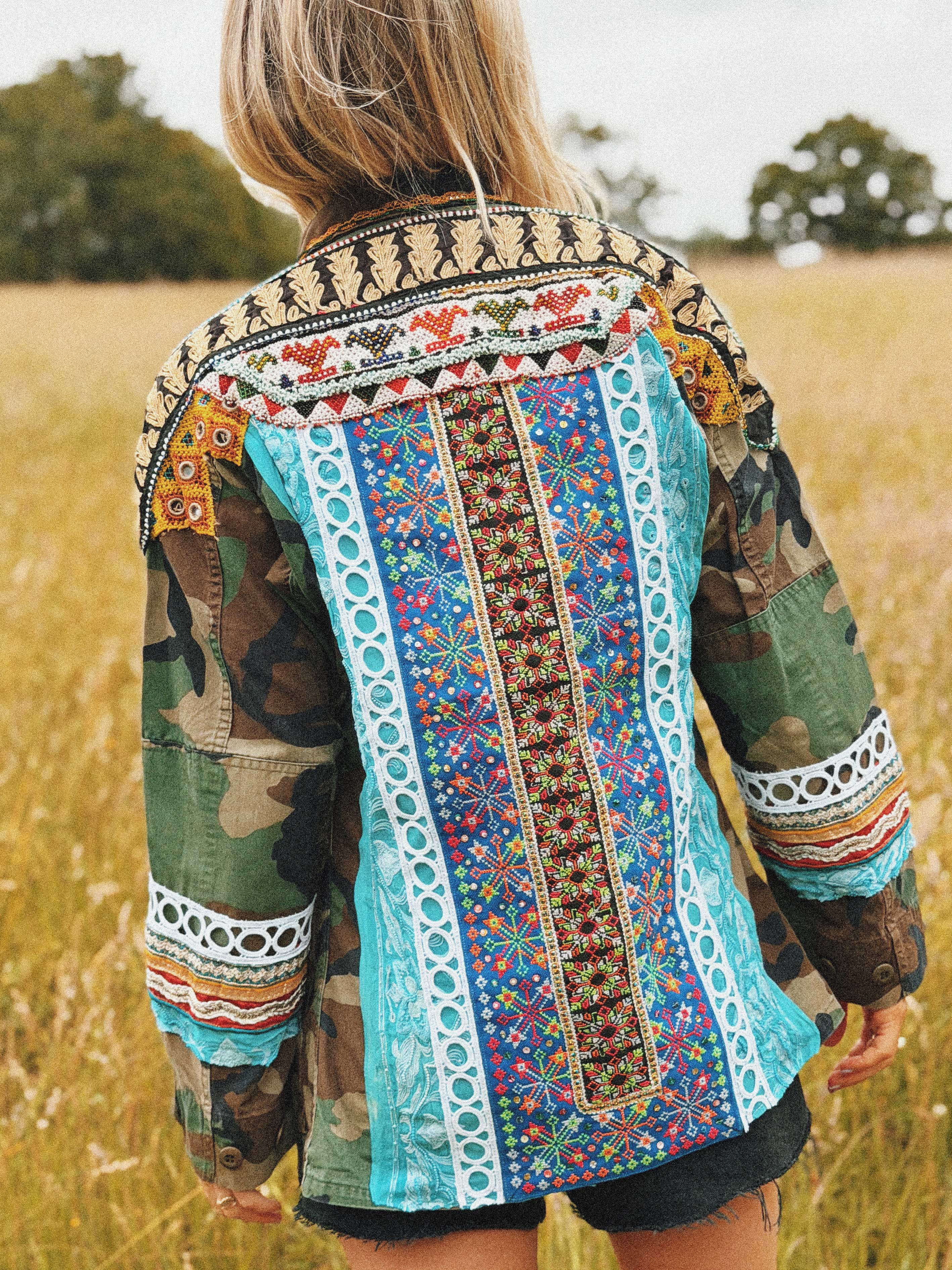 Camouflage jacket with colourful embroidered back panel and embellished trim, shown from the back.