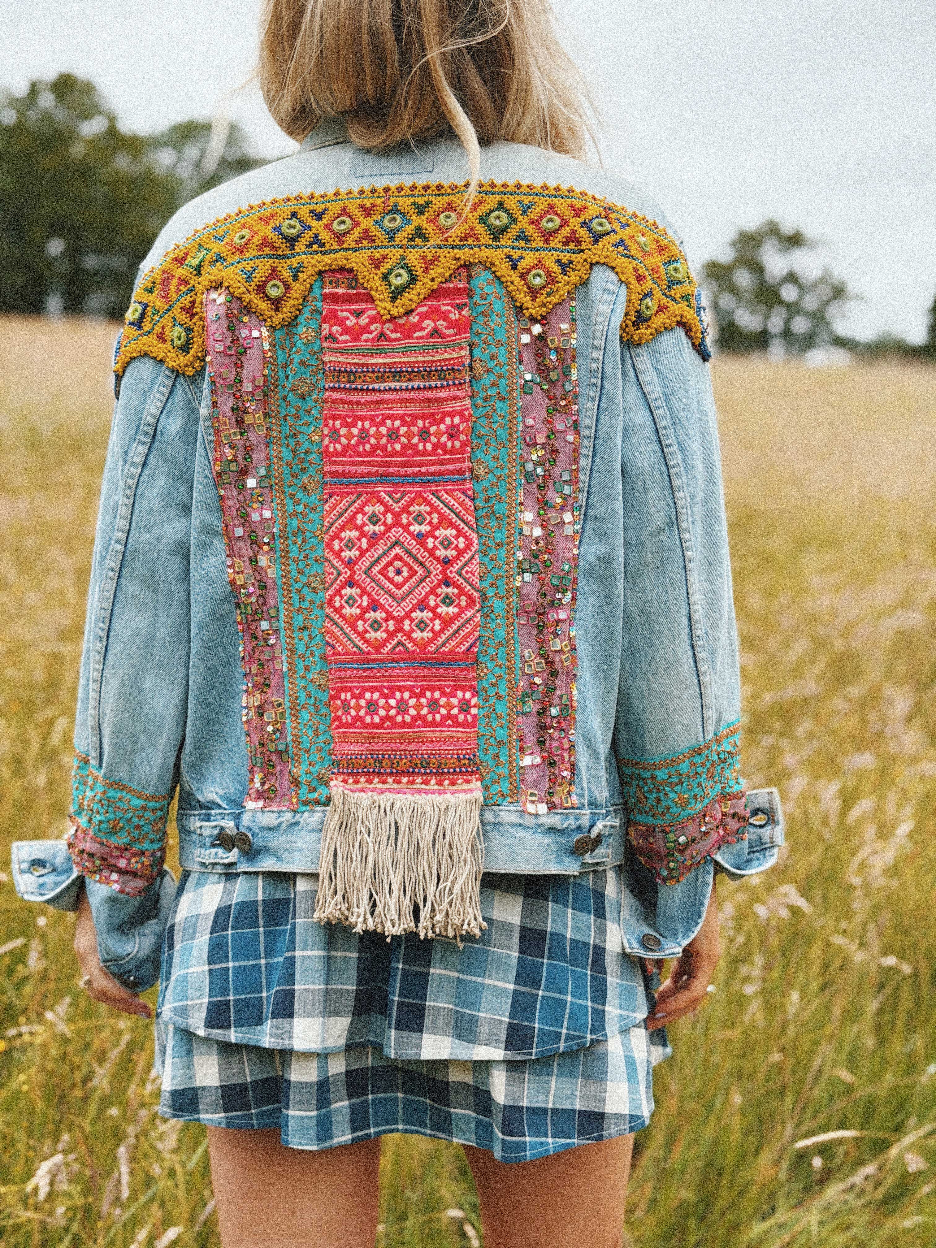 Light blue denim jacket with colourful embroidered back panel and beaded shoulder detail, shown from the back.