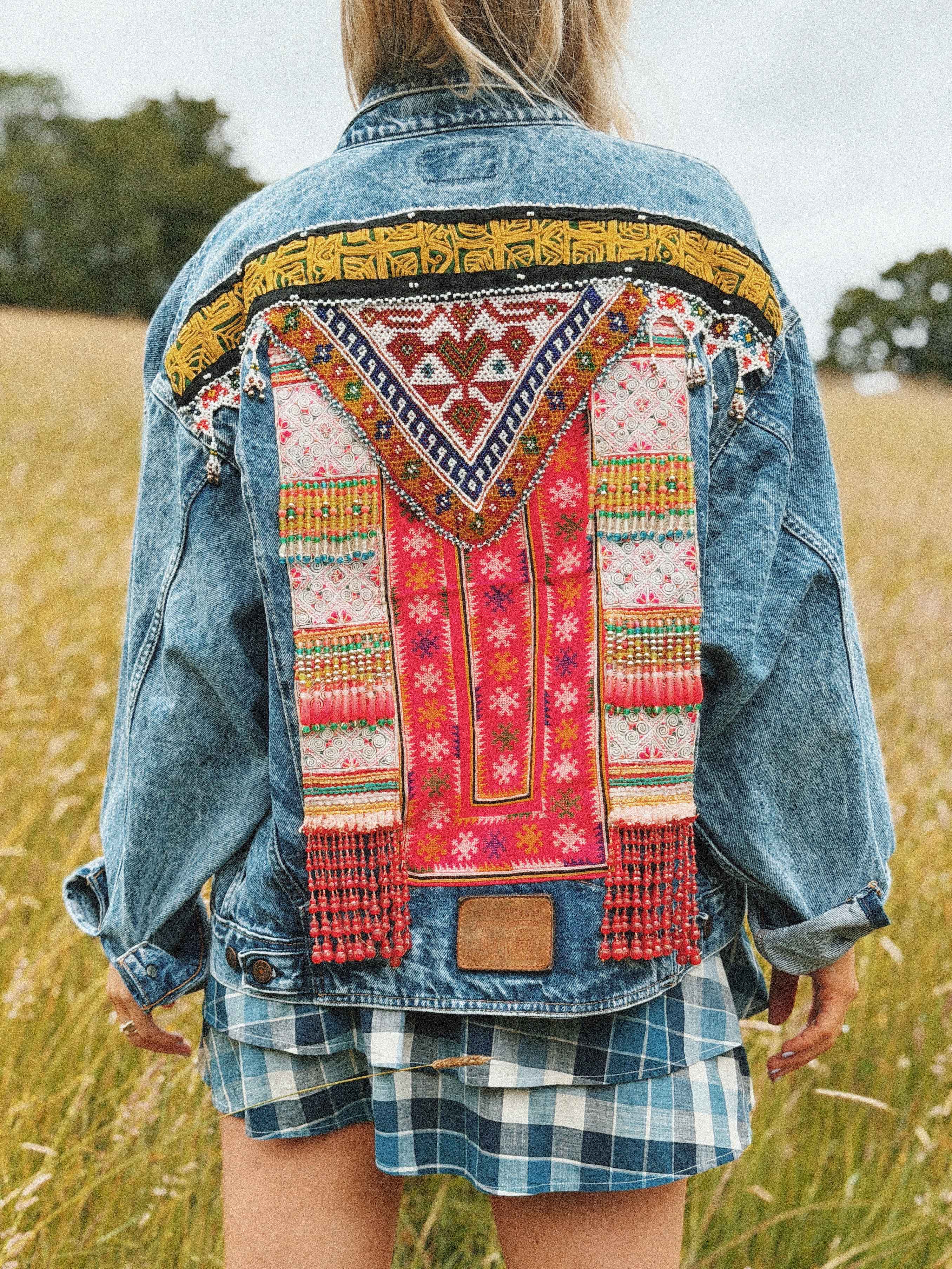 Bohemian-style blue denim jacket with colourful embroidered back detail, shown from the back.
