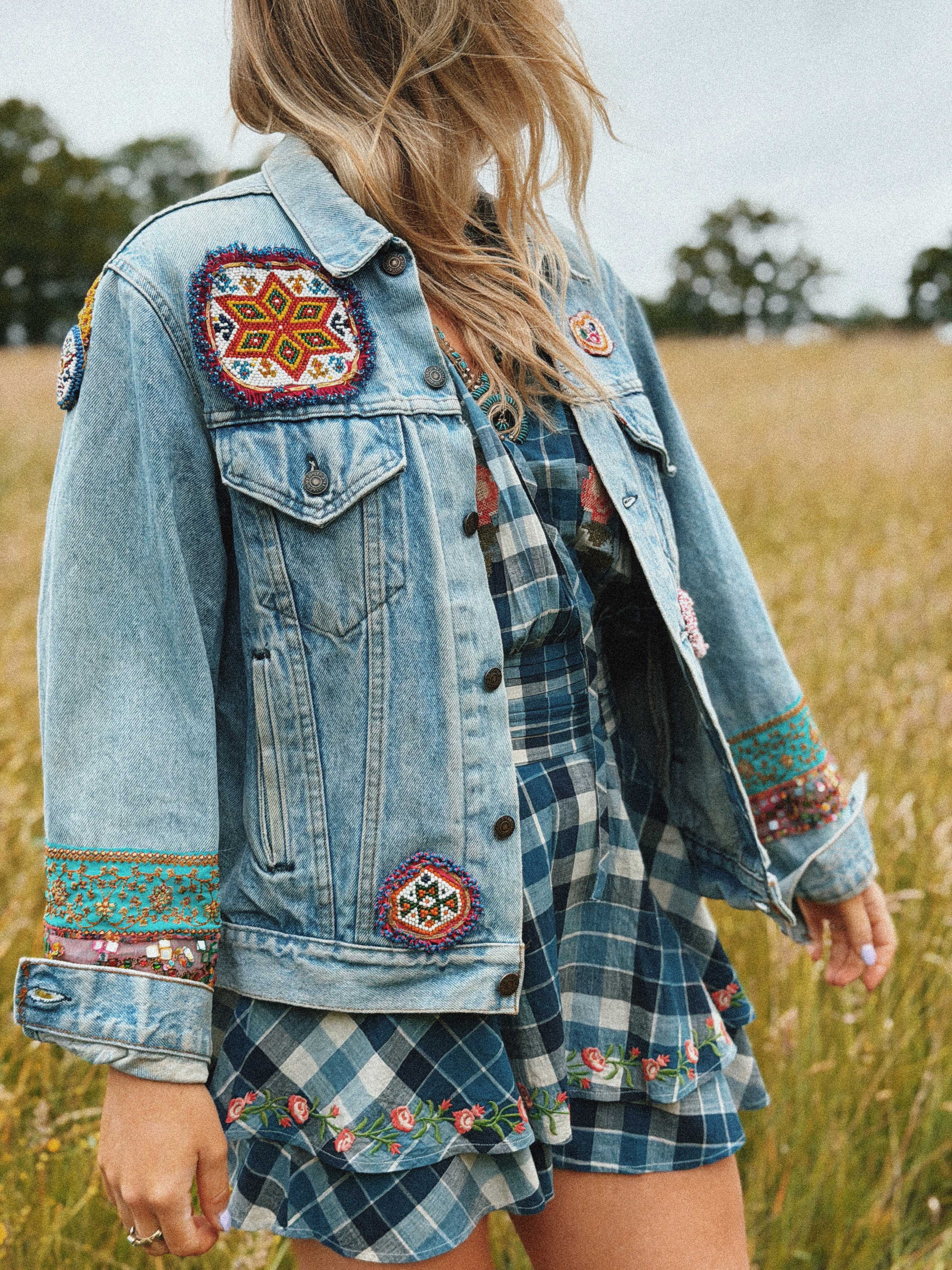 Light blue denim jacket with colourful embroidered and beaded patches, shown from the front