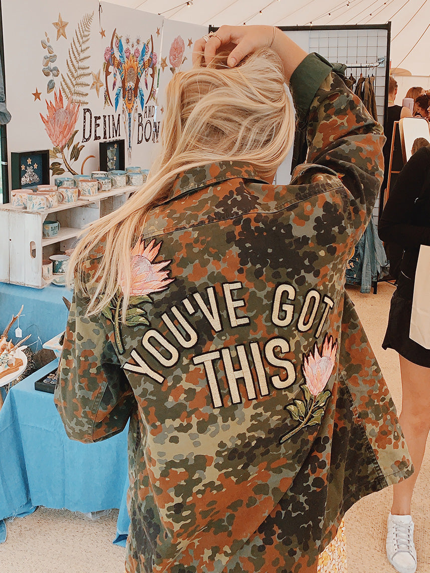 Camouflage military jacket with floral embroidered back design and "YOU'VE GOT THIS" lettering, shown from the back.