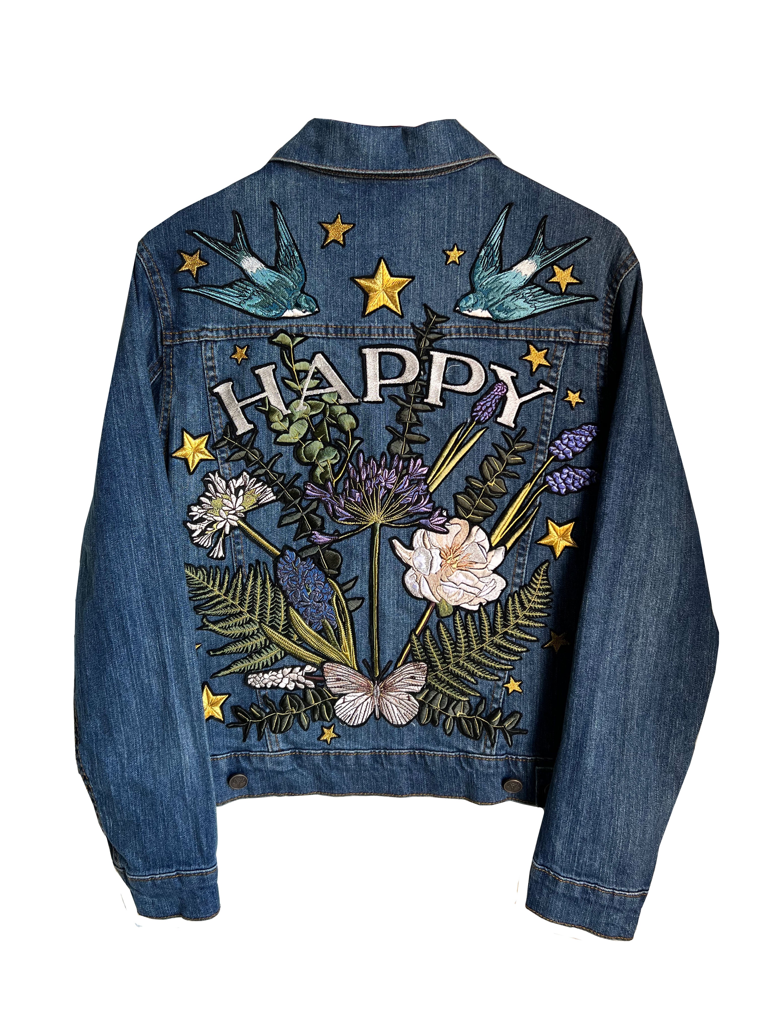 Blue denim jacket with "HAPPY" embroidered back design, floral embroidery, shown from the back.