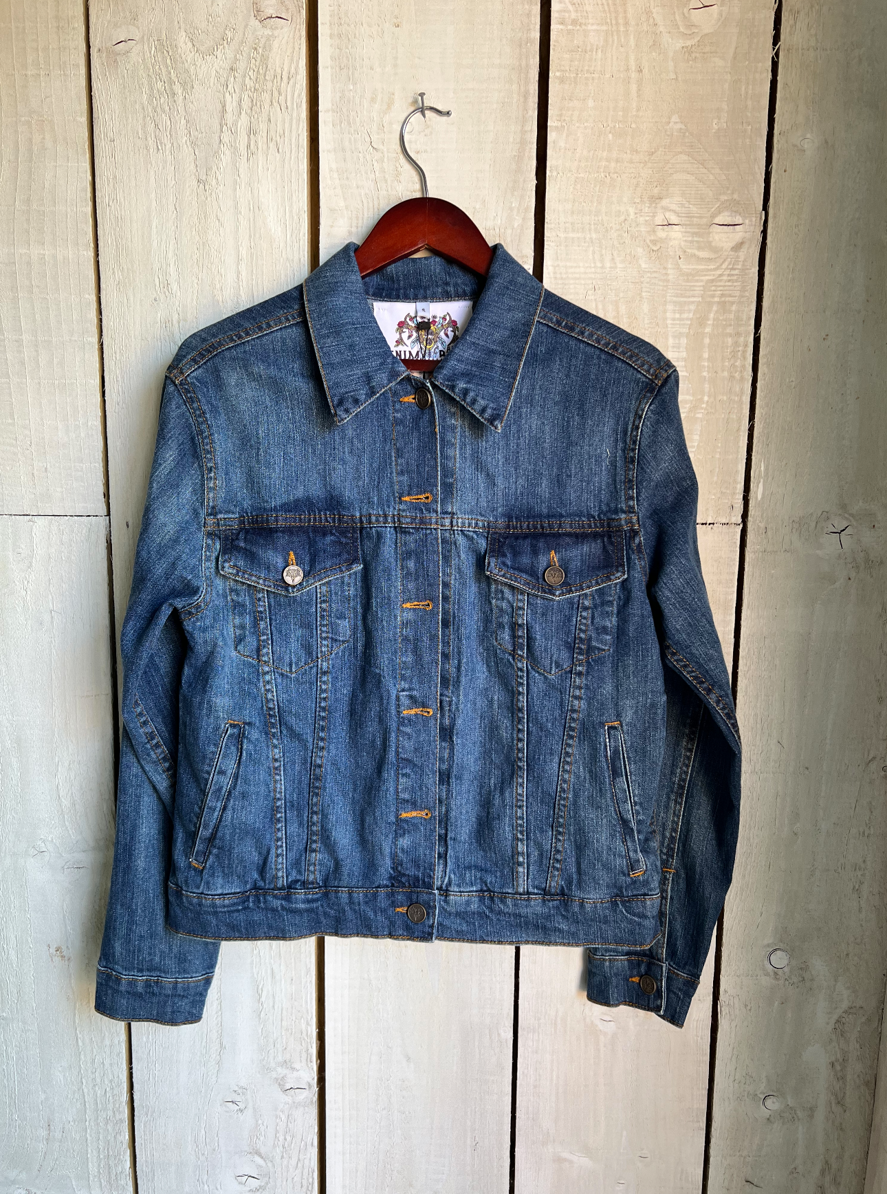 Blue denim jacket with button-front design, front view.