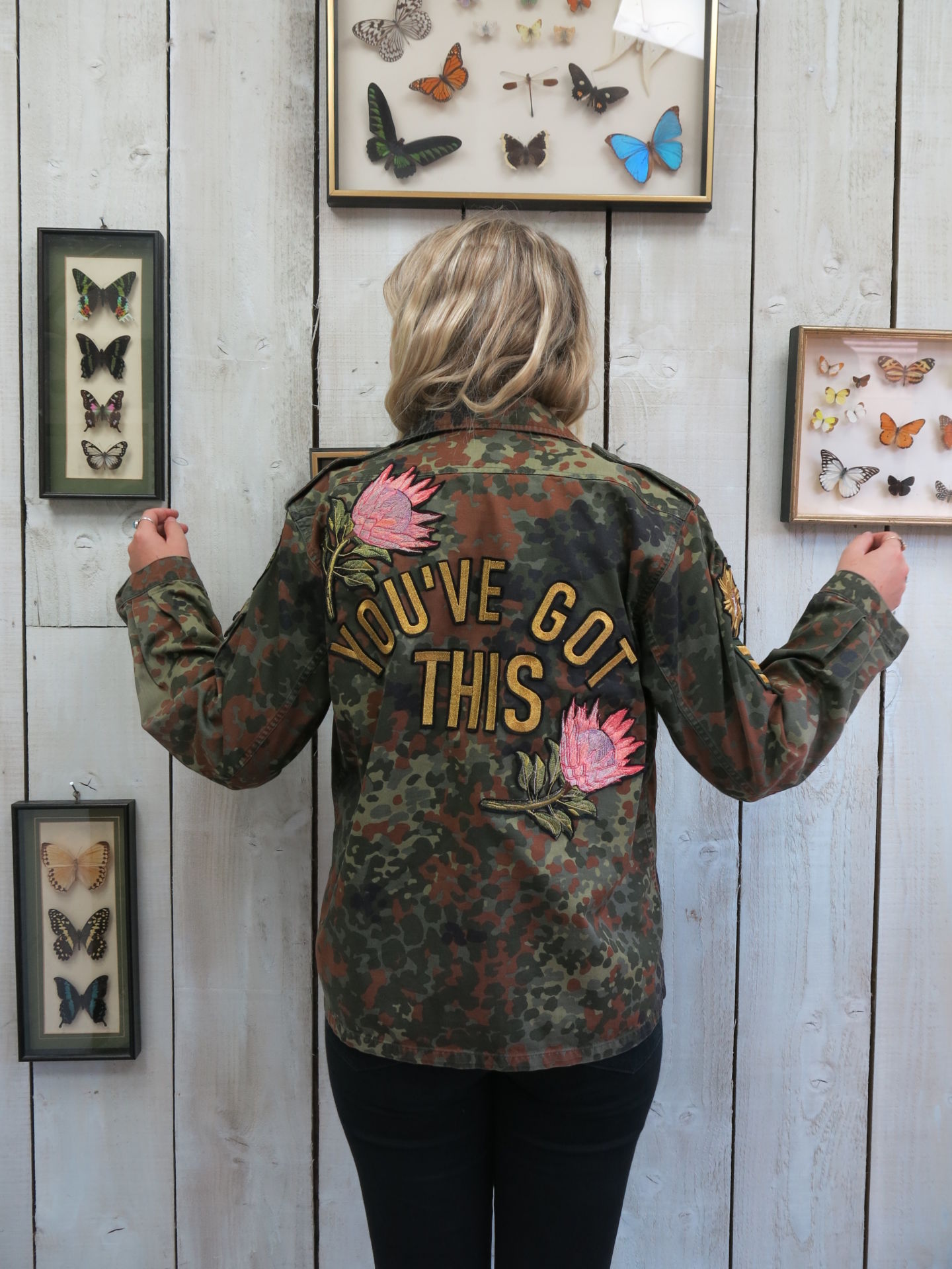 Camouflage military jacket with floral embroidered back design and "YOU'VE GOT THIS" lettering, shown from the back.